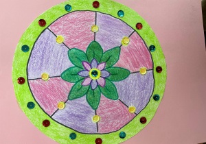 Mandala wykonana przez Kingę, uczennicę klasy 5a. W centralnym punkcie pracy znajduje się motyw roślinny wzbogacony materiałami dekoracyjnymi