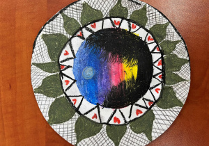 Mandala wykonana przez Majkę, uczennicę klasy 5c na papierowym talerzyku. Motyw roślinny przeplata się z motywem zachodu słońca.