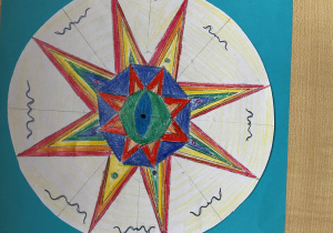 Praca symetryczna wykonana przez Natalię, uczennicę klasy 5b. Motyw kolorowej gwiazdy zajmuje centralną część pracy.