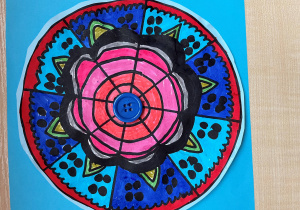 Praca z zastosowaniem kolorowych flamastrów i materiałów dekoracyjnych .Mandala wykonana przez Wiktorię, uczennicę klasy 5b