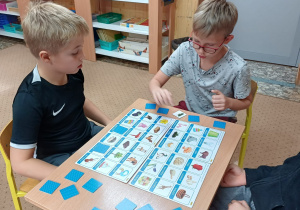 Gra logopedyczna – Psotne słówka. Uczniowie szukają pary do obrazków na swojej planszy.