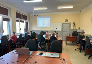 Grupa uczniów podczas zajęć koła informatycznego uczy się edytować i prace graficzne.